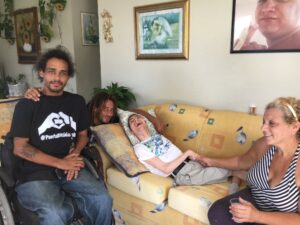 Image of Germán, sitting in his wheelchair next to 3 Hurricane Maria survivors.